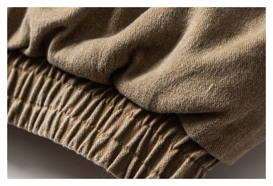 Close-up of tan fabric gathered above a ribbed elastic waistband.