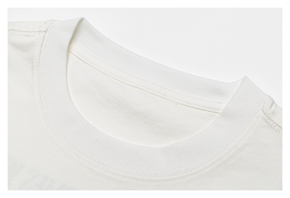 Close-up of the ribbed crew neckline and stitching on an off-white T-shirt.