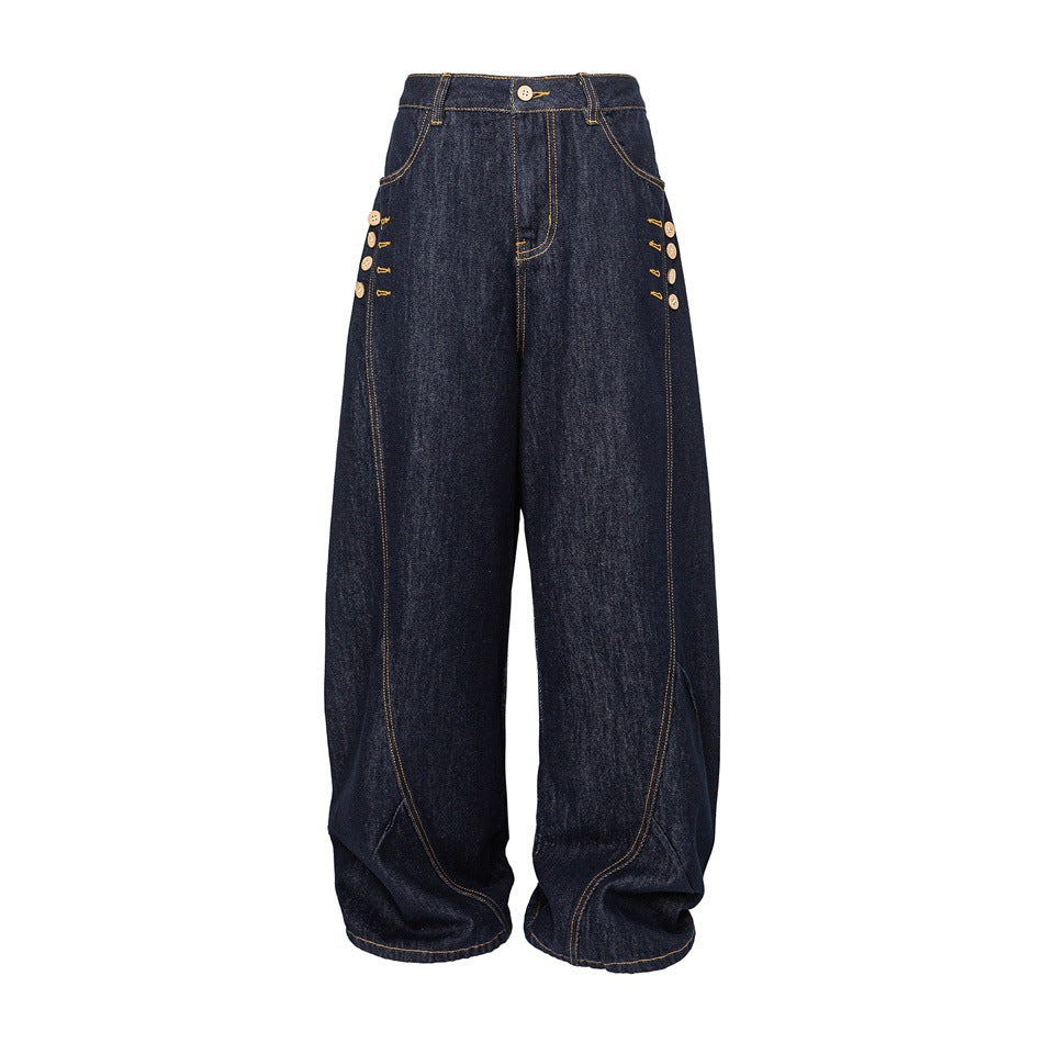 Front of dark indigo wide-leg barrel jeans with golden topstitching and decorative side buttons