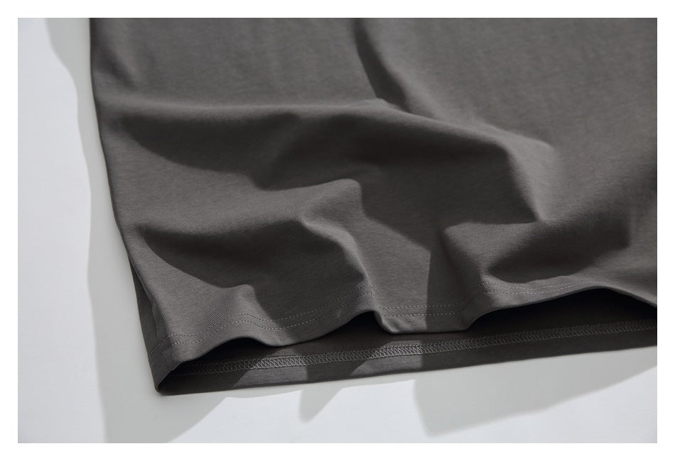 Close-up of the charcoal shirt's hem, showing double stitching and the underside seam.