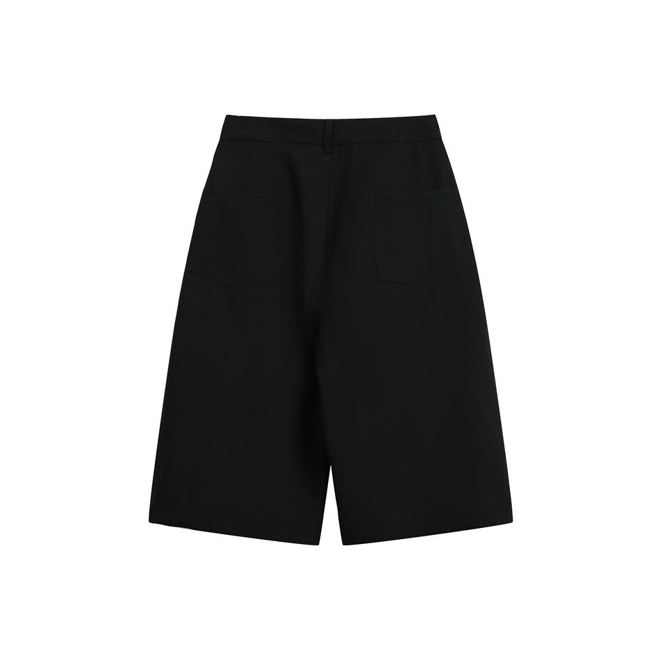 Back view of black knee-length wide-leg shorts with two rear patch pockets and a belt loop.