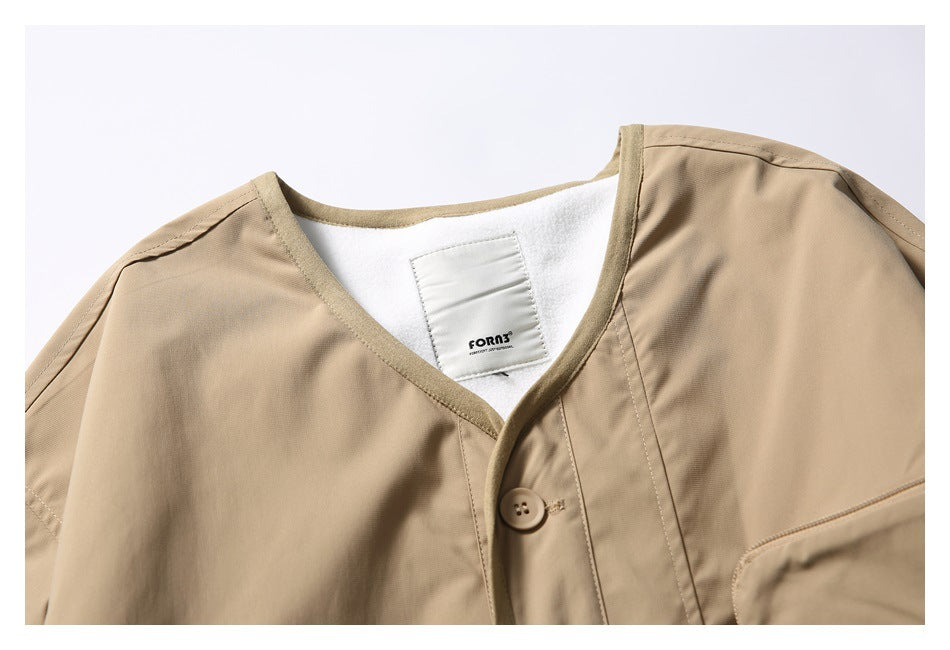 Close-up of the tan jacket's neckline, bound edges, button, inner lining, and sewn-in label.