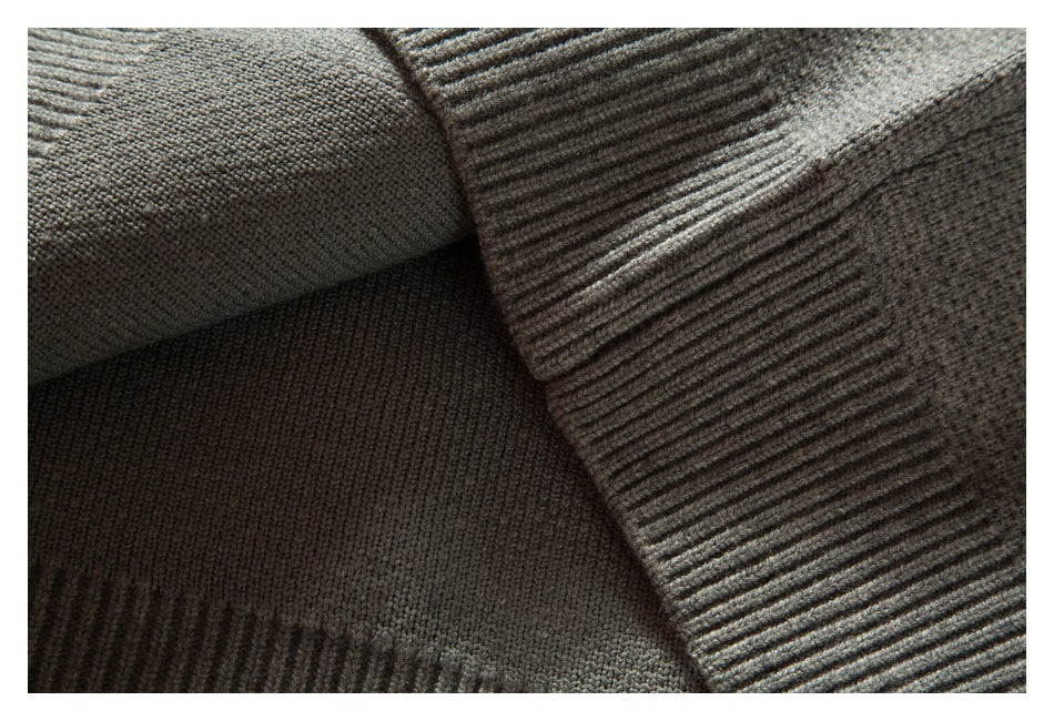Close-up of folded ribbed knit trim against the textured gray garment.