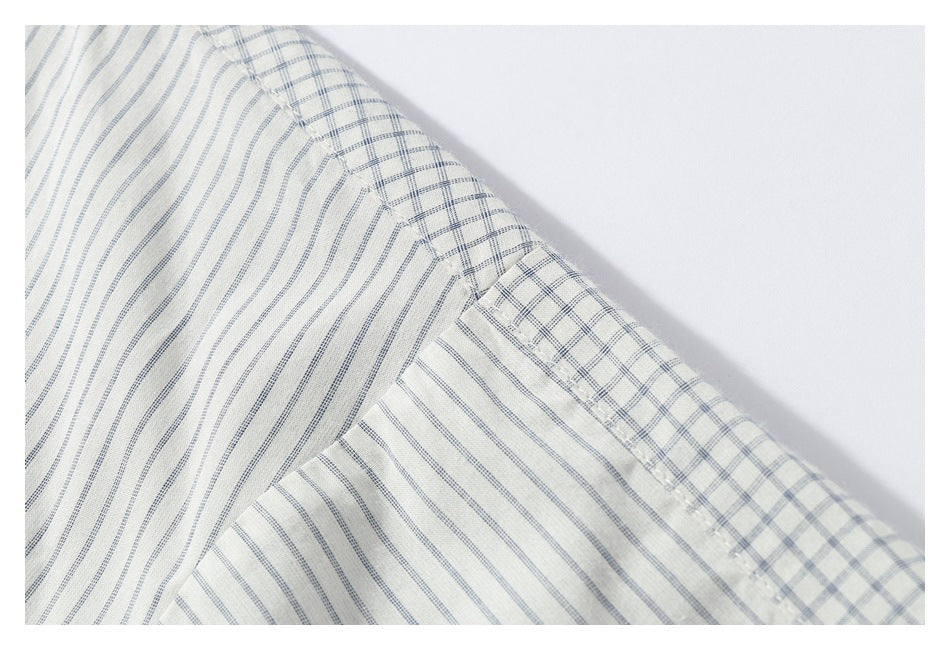 Close-up of the shirt's shoulder and sleeve seam, showing vertical gray stripes and checked fabric at the seam.