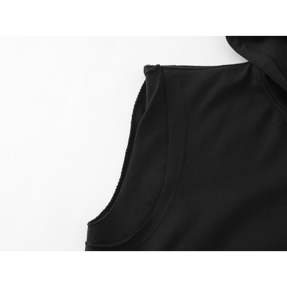 Close-up of the black sleeveless hoodie’s armhole seam and edge stitching.