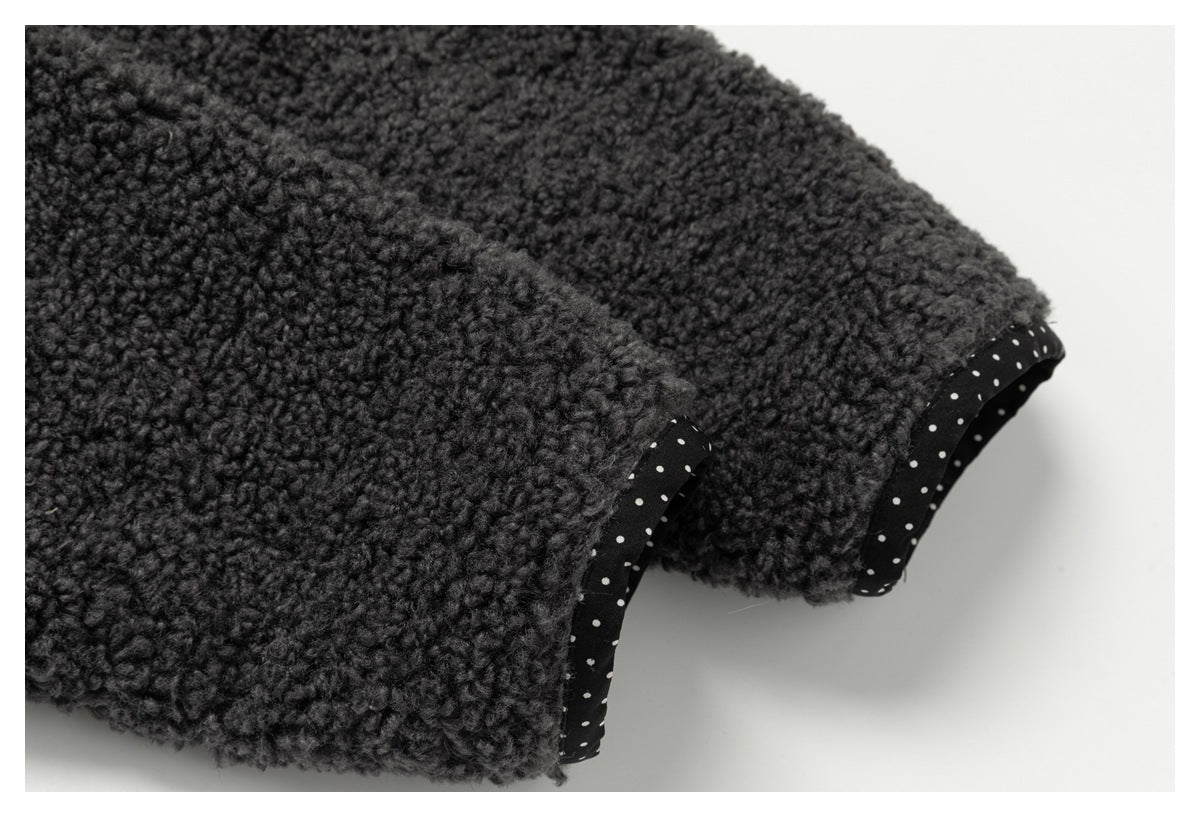 Close-up of charcoal loop-textured fabric with black trim dotted in white along two edges.