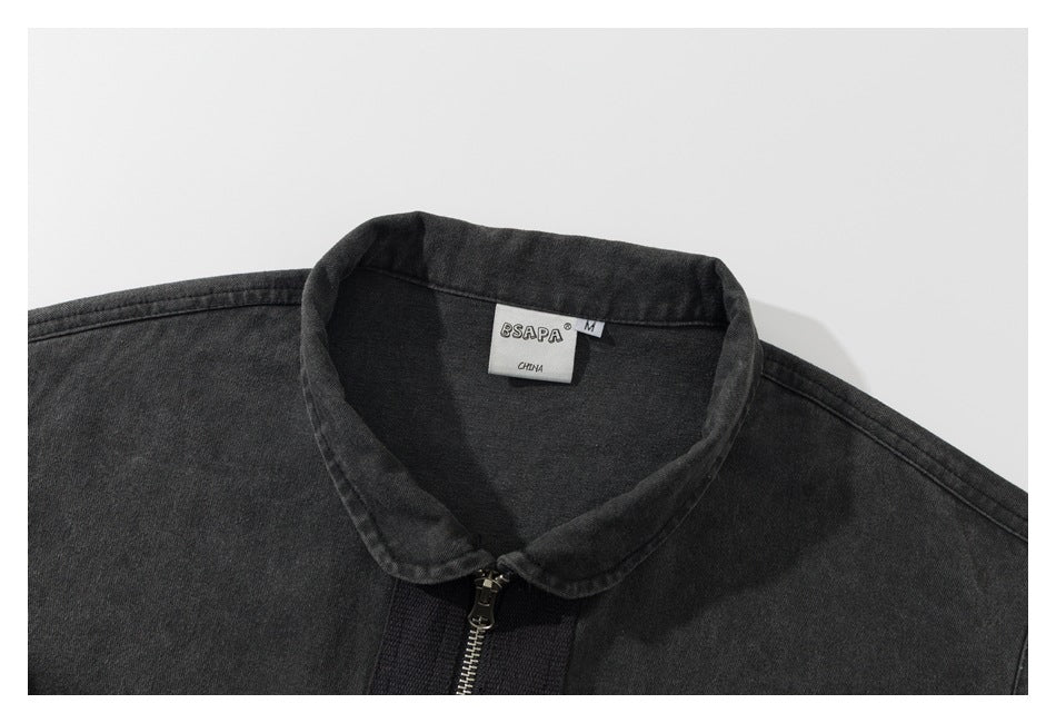 Close-up of a charcoal washed garment's rounded collar, zipper, and neck label.