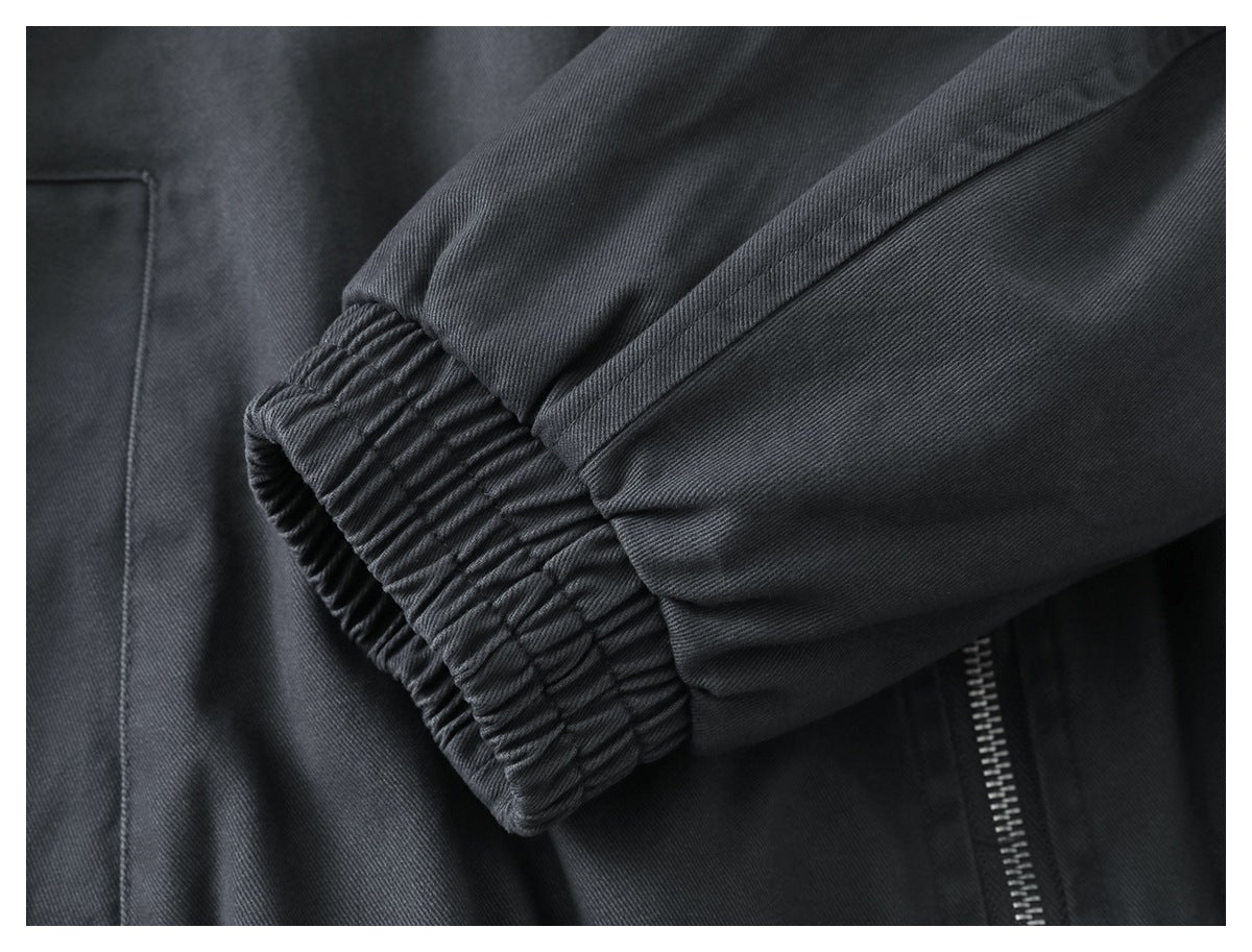 Close-up of the charcoal jacket’s gathered elastic sleeve cuff and sleeve seam.