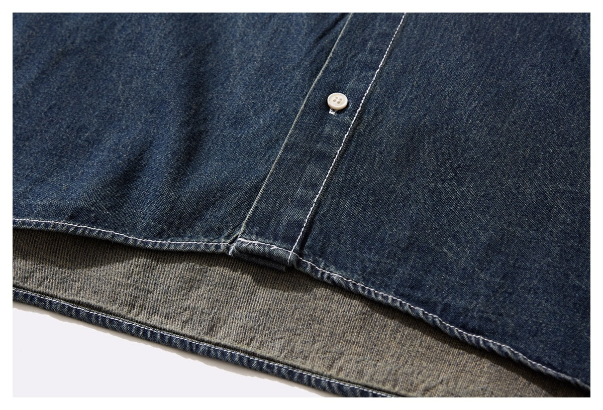 Close-up of the dark indigo denim shirt hem, showing contrast stitching and the reverse fabric.