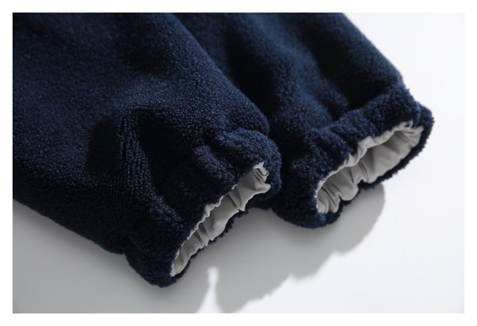 Close-up of navy textured fleece garment edges with gathered light gray lining visible inside.