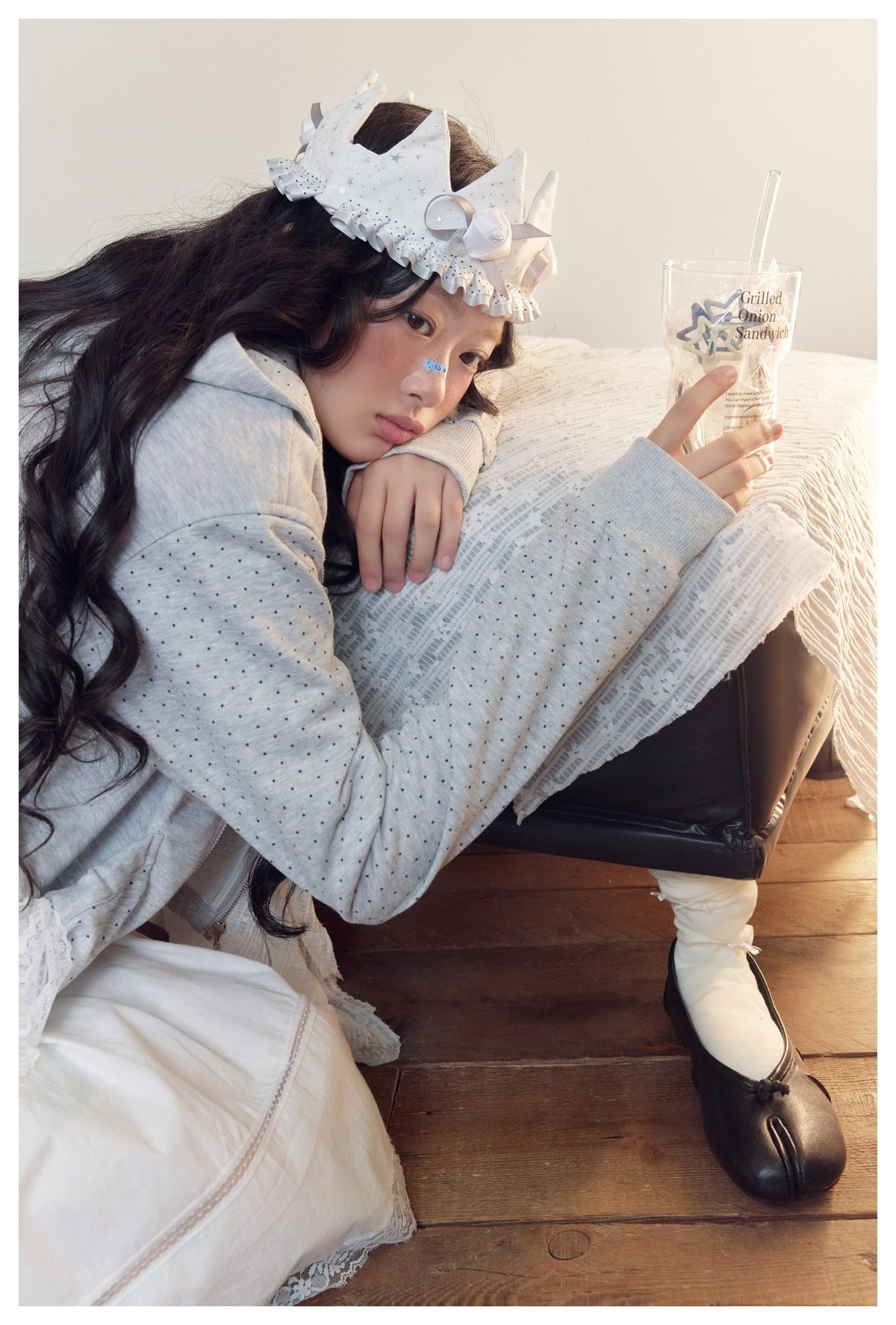 Model leaning on a chair in a light gray dotted zip hoodie; the hood lining is also dotted.