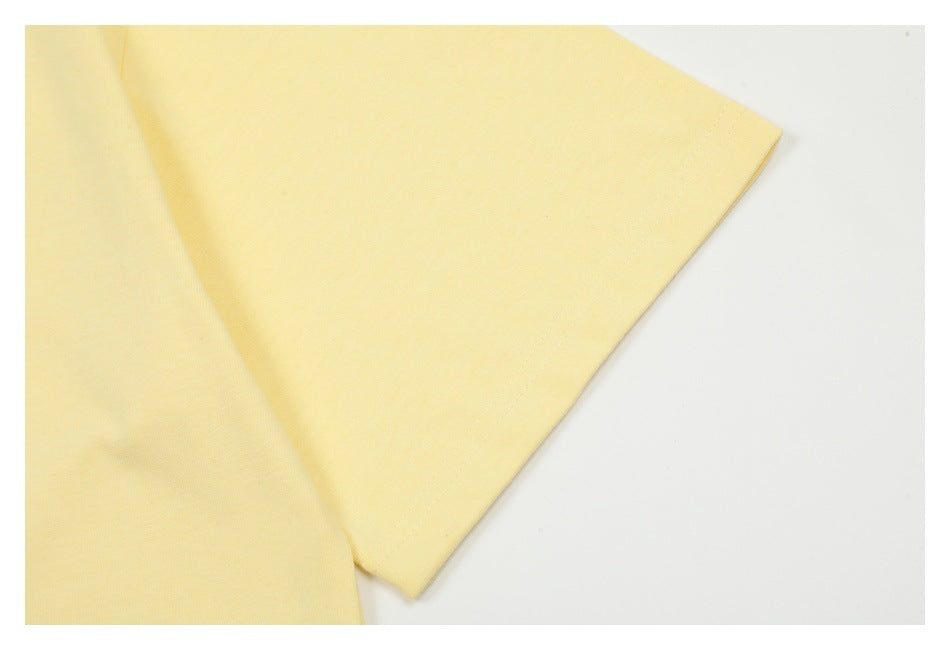 Close-up of the pale yellow T-shirt's short sleeve and stitched hem.
