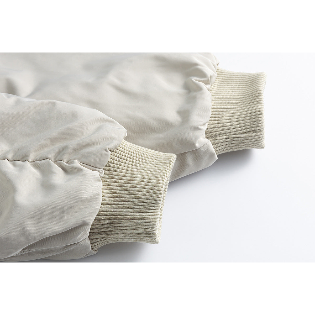 Close-up of the light gray jacket's gathered sleeves and cream rib-knit cuffs.