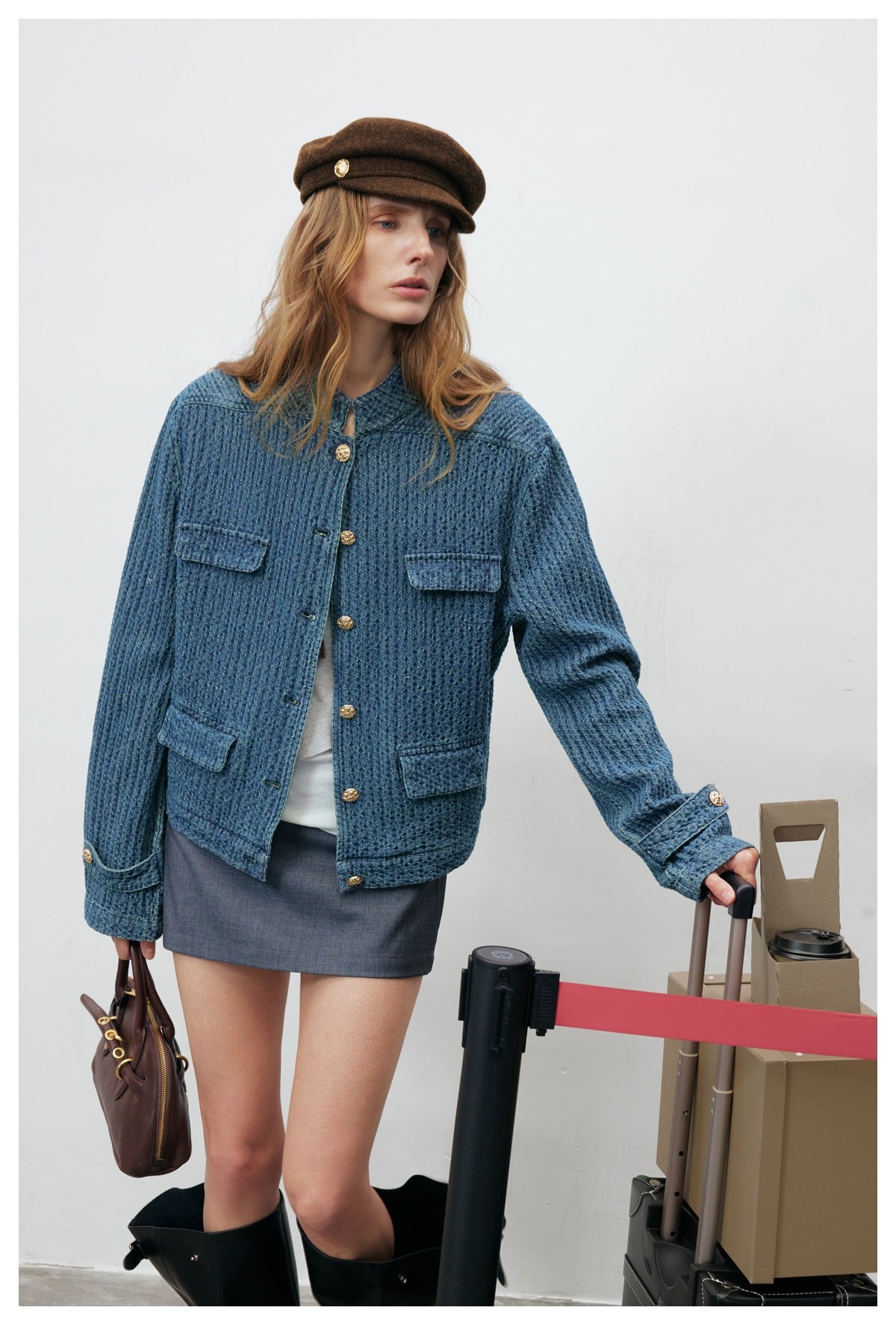 Model wearing a blue textured jacket with gold buttons and four flap pockets, shown from the front.