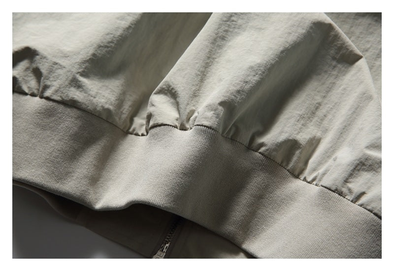 Close-up of a pale gray garment gathered into a wide ribbed knit hem.
