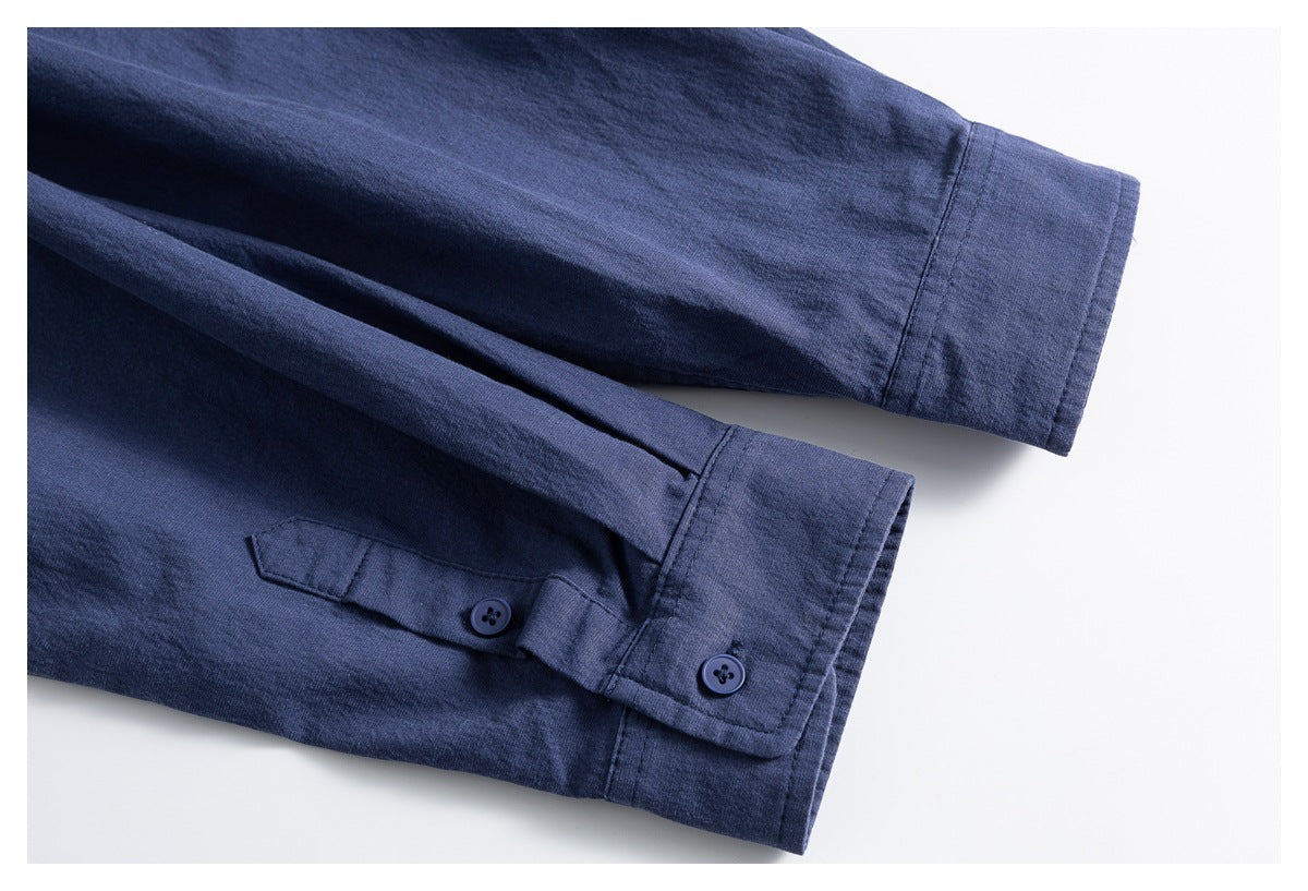 Close-up of a blue shirt's long sleeve and buttoned cuff with an adjustable tab.