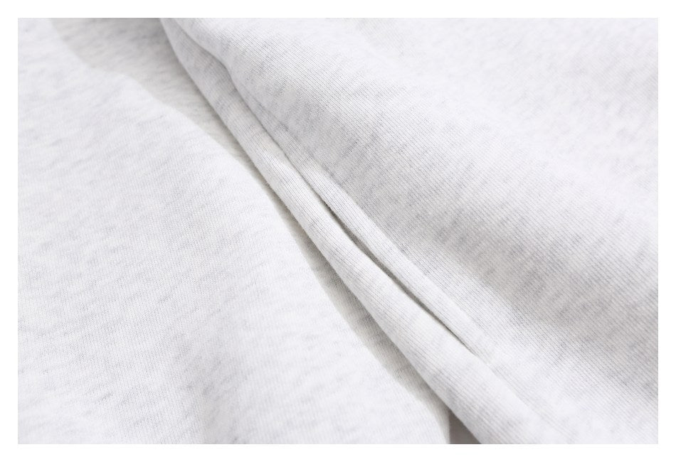 Close-up of light gray heathered fabric and a stitched seam.