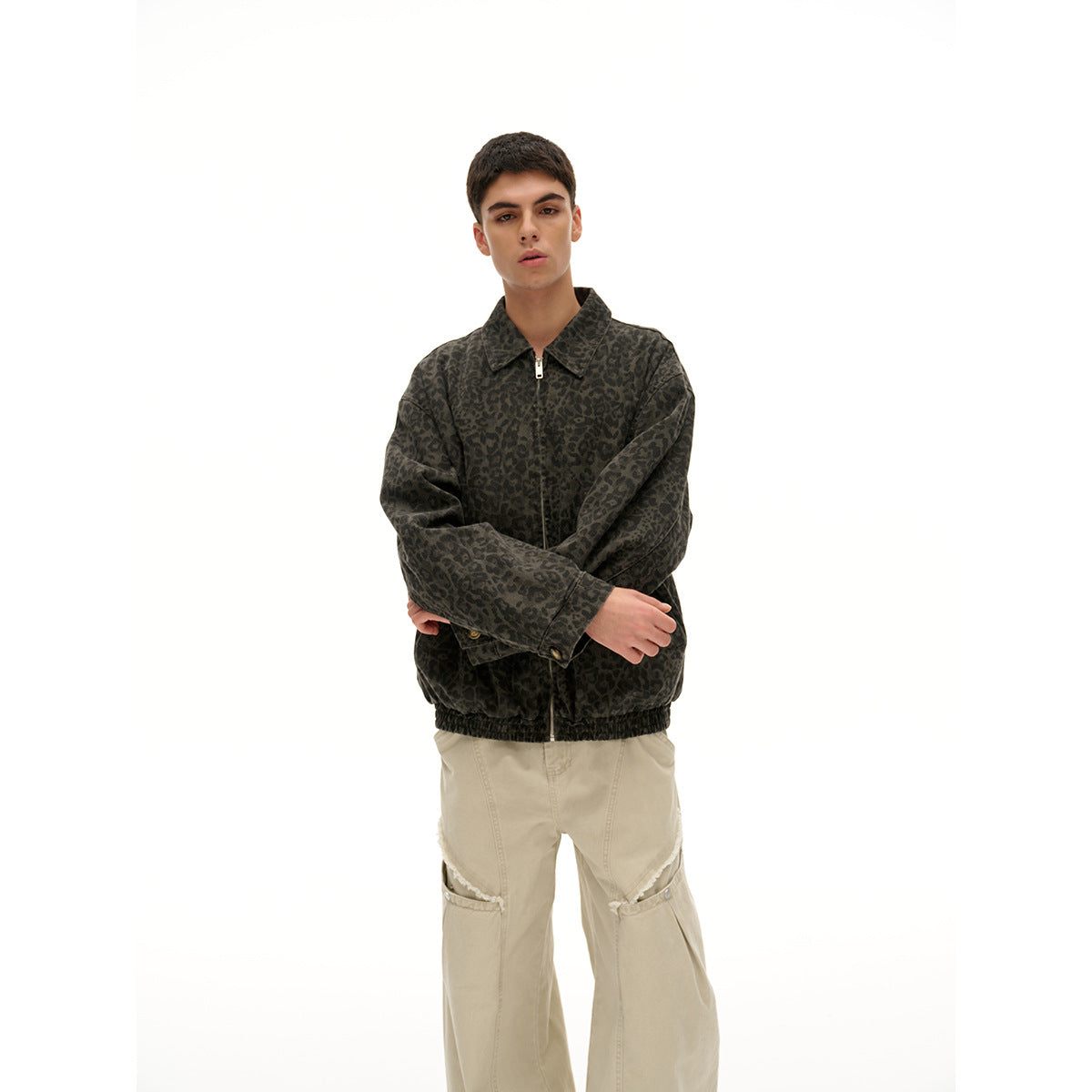 Closer view of a model in a dark leopard-print zip jacket and cream cargo pants.
