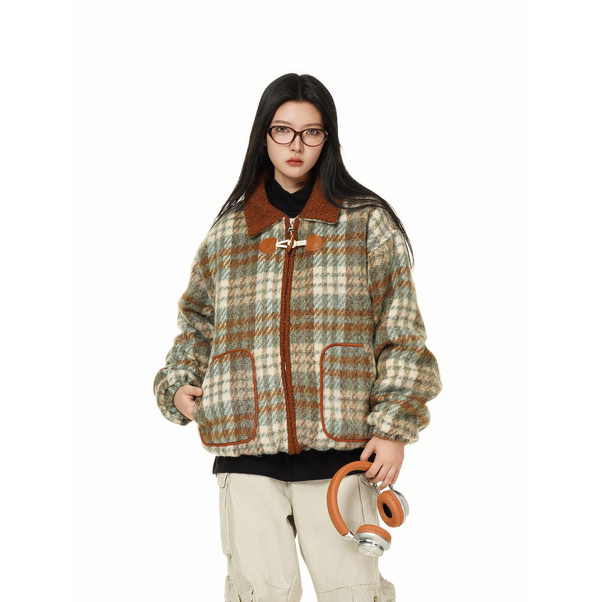 Model wearing a cream, teal, and rust plaid jacket with a rust collar, toggle closures, and large front pockets.
