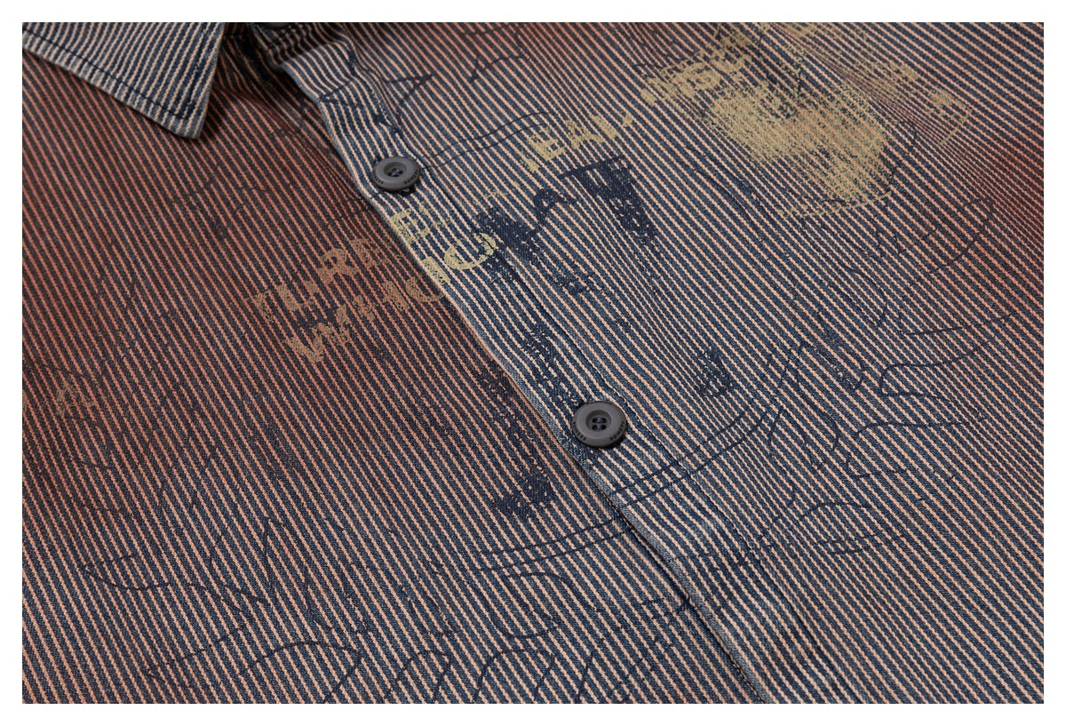 Close-up of a navy and rust diagonal-striped shirt with dark buttons and a faded graphic print.