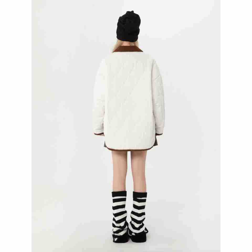 Back view of a model wearing a white jacket with a brown collar and brown edging.