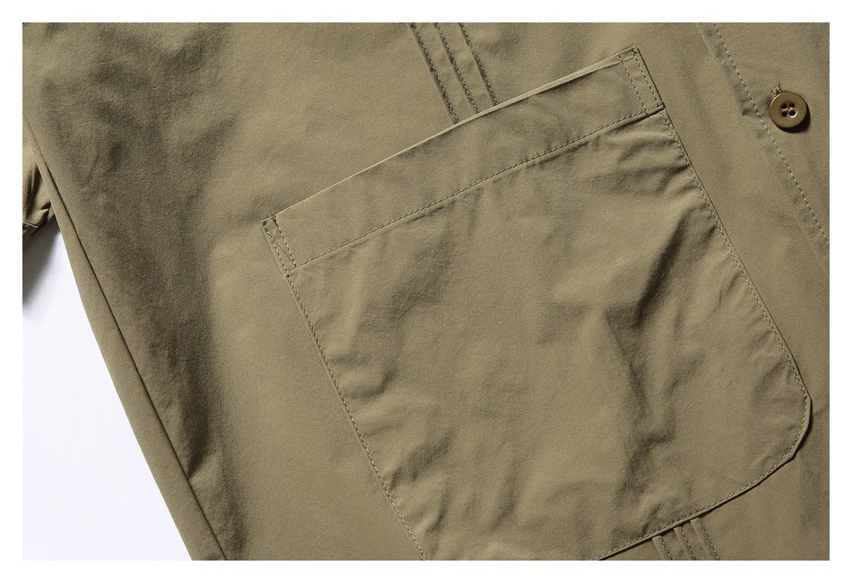 Close-up of the olive-khaki shirt's large patch chest pocket, stitching and front button.