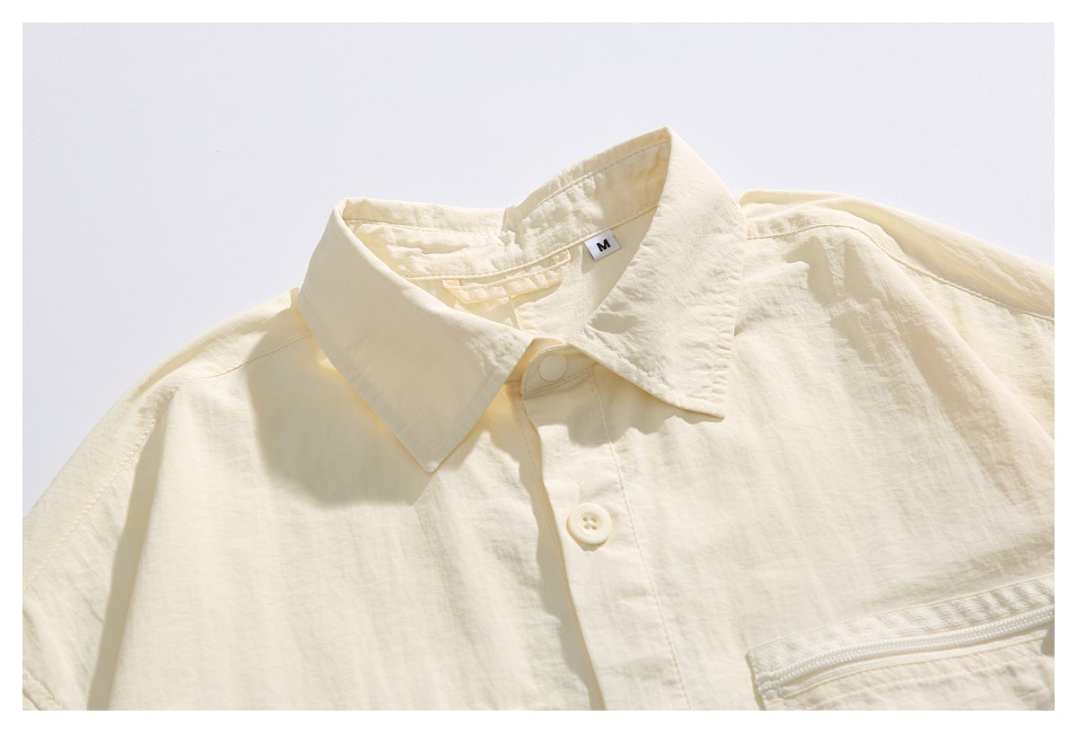 Close-up of an ivory shirt collar, snap-button placket, and upper chest pocket; an M size label is visible.
