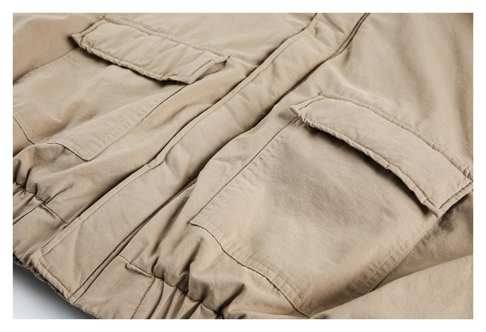 Close-up of the tan jacket front with two large flap pockets and a central placket.