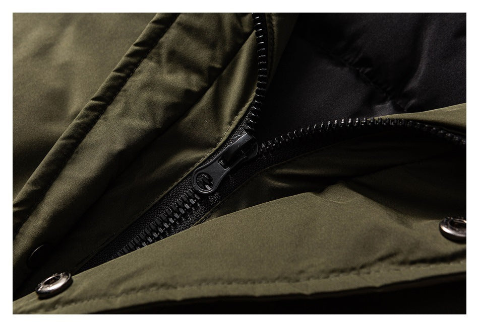 Close-up of the black zipper and snap-fastened placket on an olive jacket.