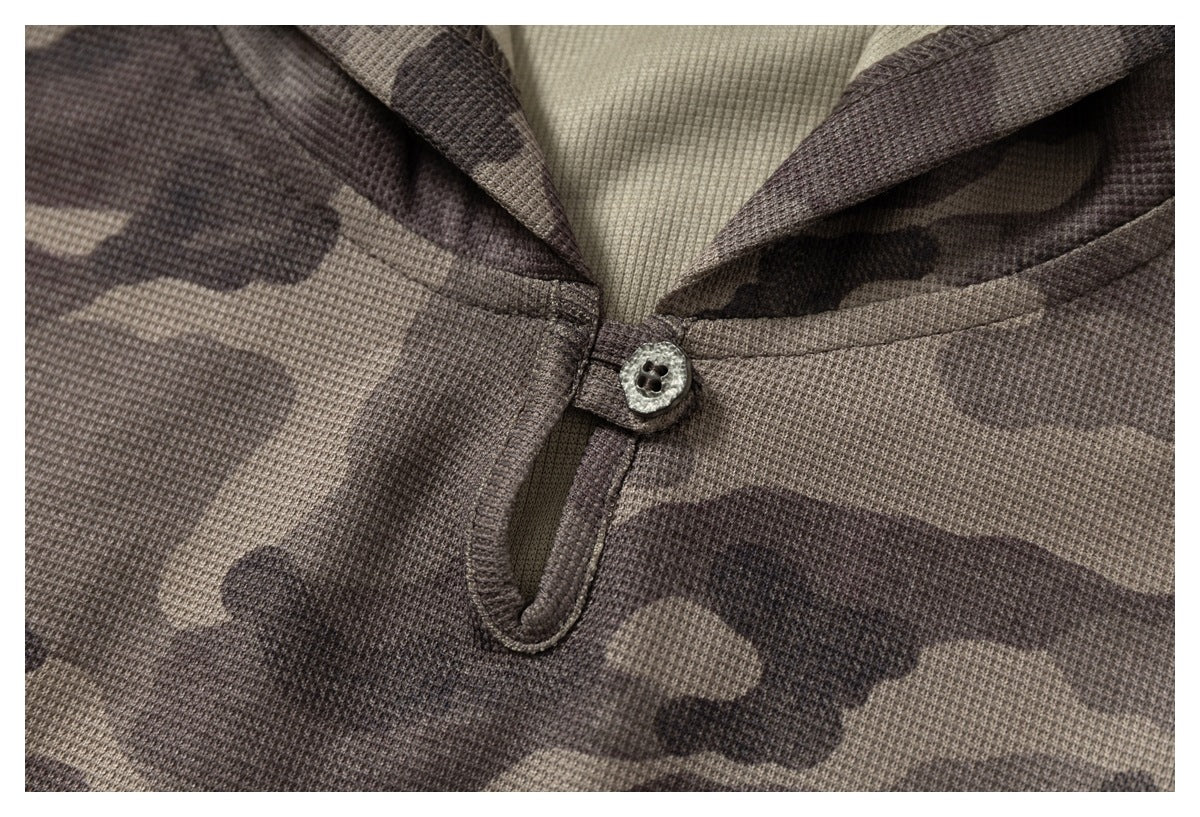 Close-up of the camouflage shirt's buttoned neckline, showing a small button and short front opening.