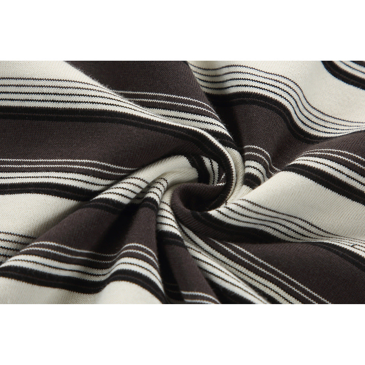 Close-up of brown-and-ivory striped fabric gathered into folds, showing its surface and pattern.