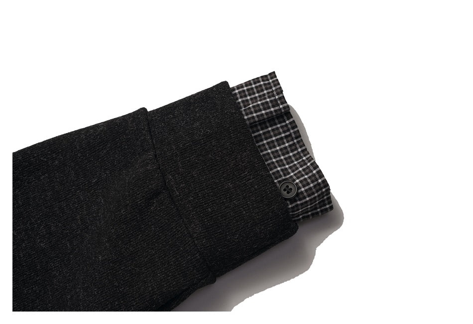 Folded charcoal sleeve with a black-and-white checked cuff lining and a small black button.