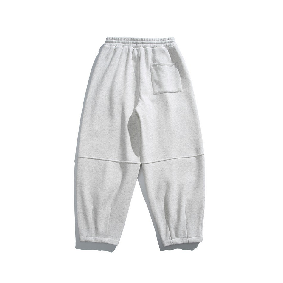 Back view of light gray relaxed-fit joggers with an elastic waistband, rear patch pocket and paneled legs.