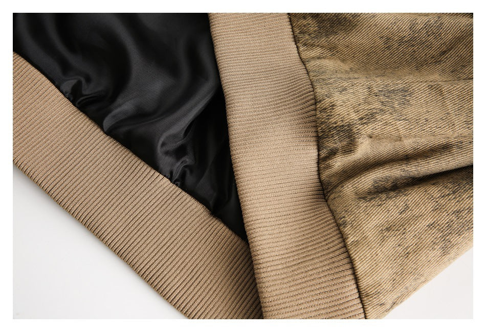 Close-up of the jacket interior showing black lining and a wide tan ribbed hem beside mottled fabric.