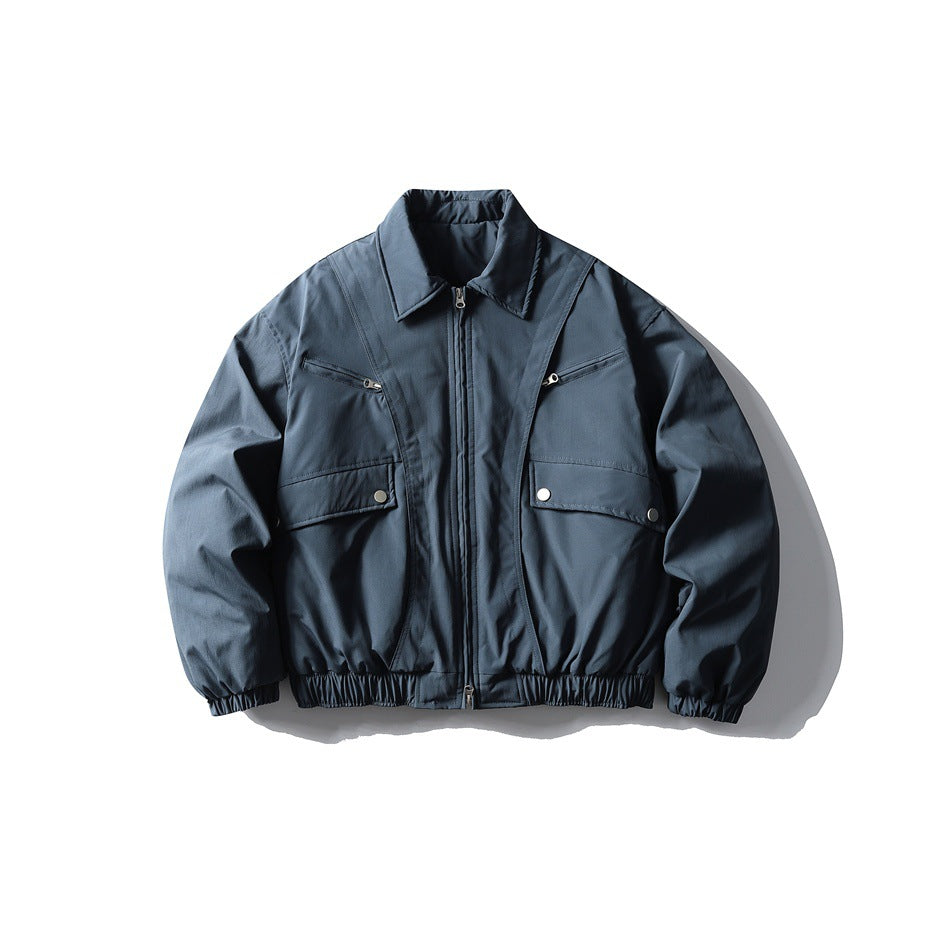 Gray-blue zip-front padded jacket with pointed collar, flap pockets, chest zip pockets and elastic hem, flat lay