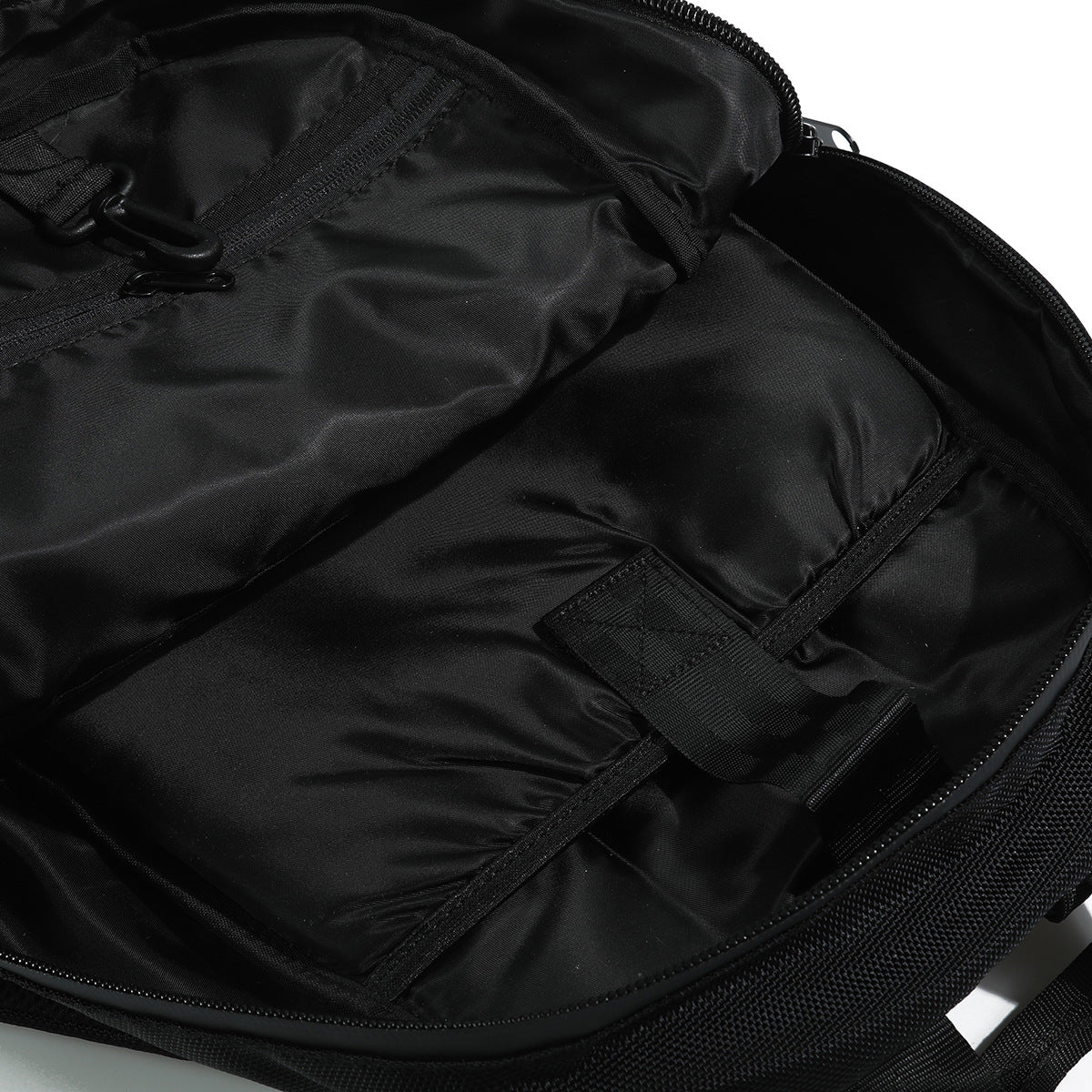 Open black bag interior showing lining, zipper, and internal straps.