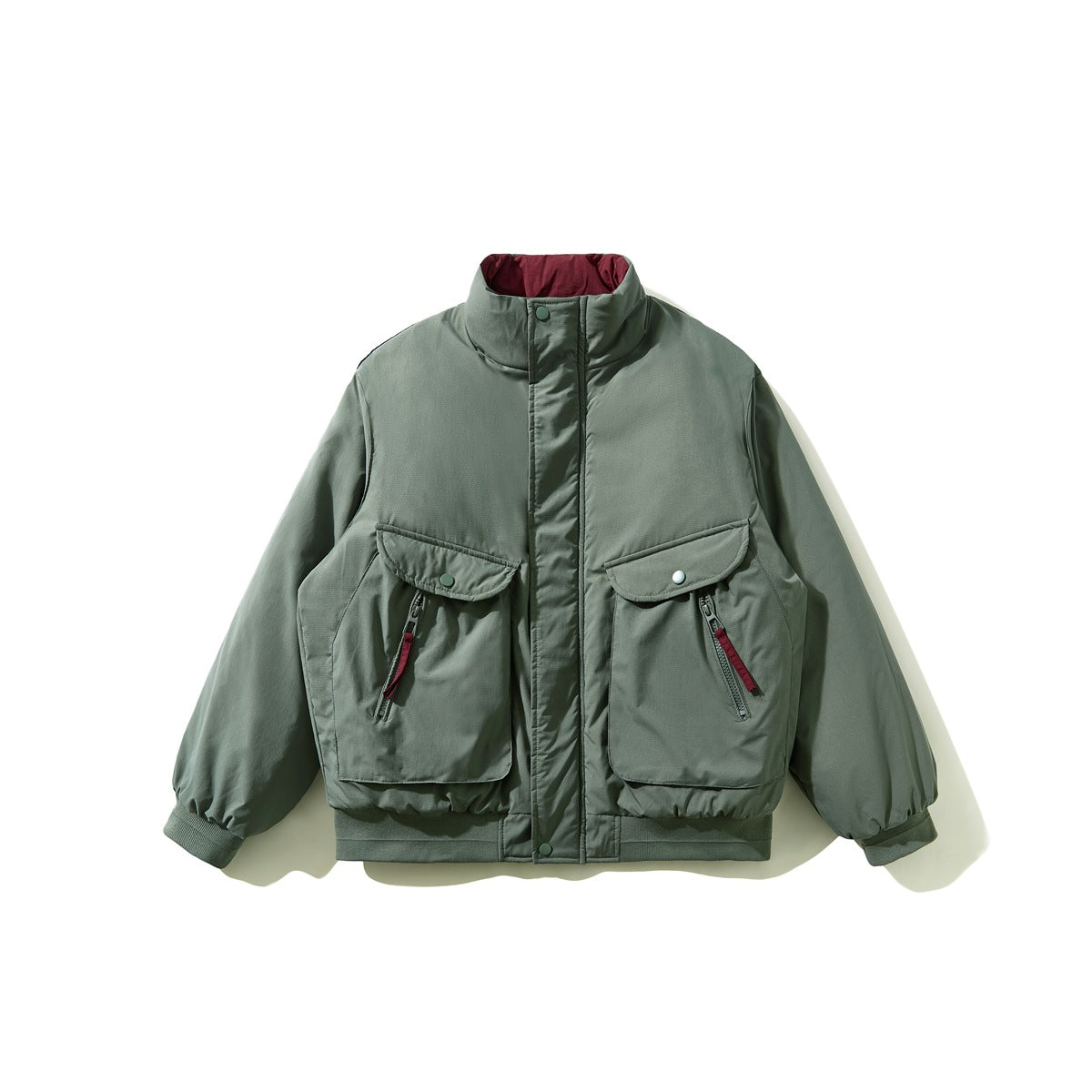 Gray-green padded stand-collar jacket flat lay with two large flap pockets and burgundy zipper pulls
