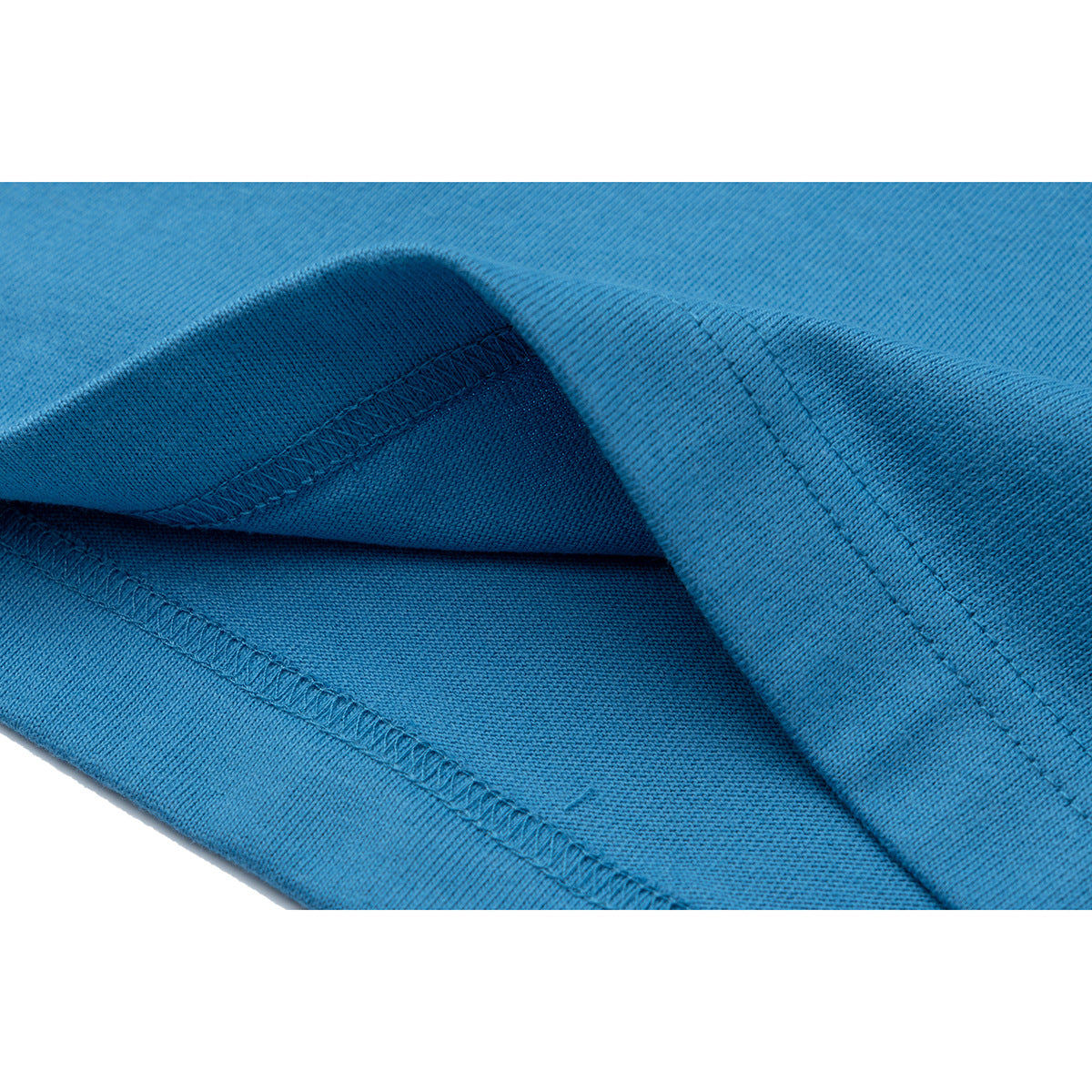 Close-up of blue T-shirt fabric folded to show the hem and stitching.