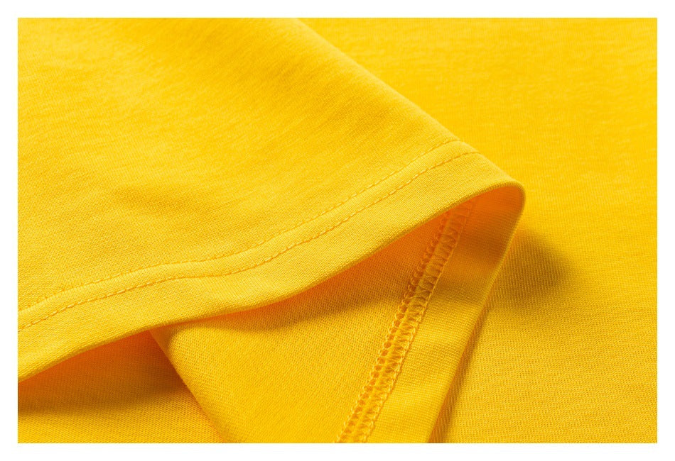 Close-up of bright yellow garment fabric showing a folded hem and interior overlock stitching.
