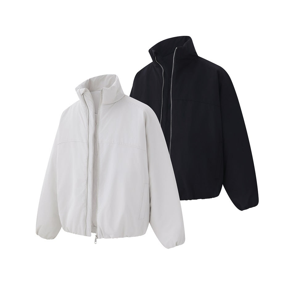 White and black zip-front jackets with tall collars, long sleeves, and gathered hems.