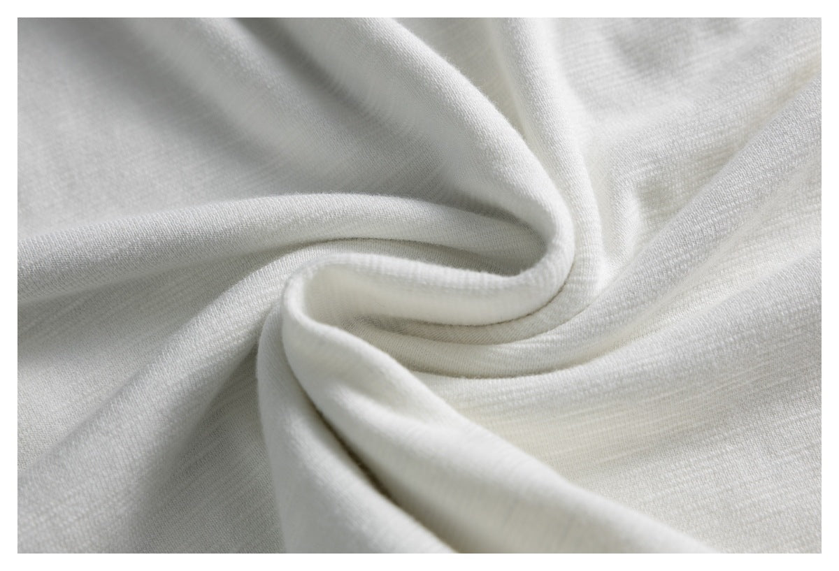 White knit fabric draped into soft folds, showing its smooth textured surface.