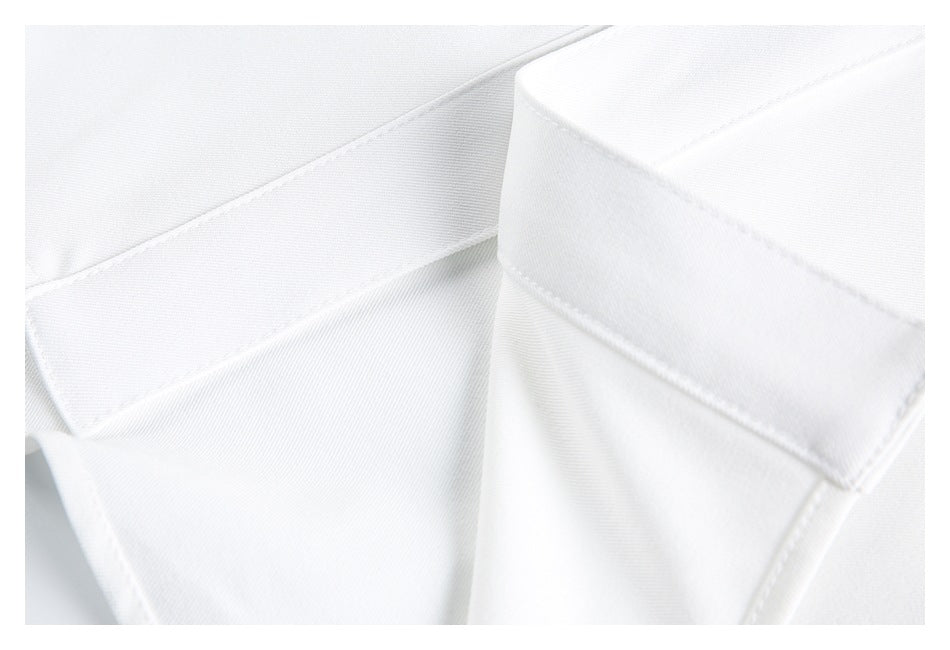 Close-up of overlapping white garment panels with stitched edges.