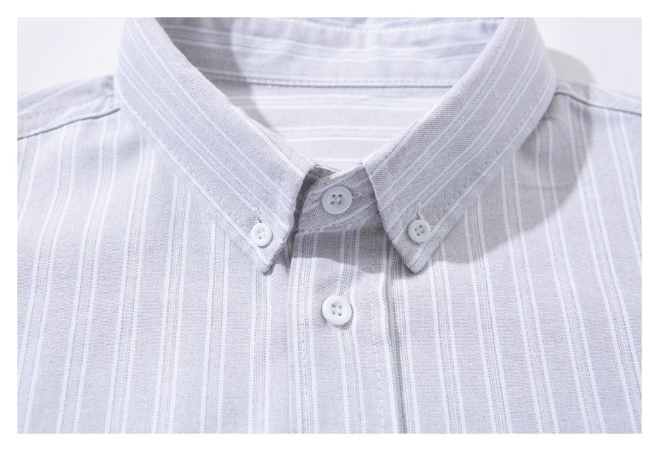 Close-up of a pale gray striped shirt's button-down collar and front buttons.