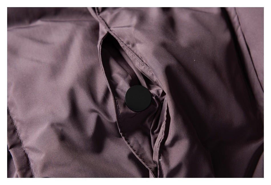 Close-up of a black snap fastener beneath the dusty mauve garment's overlapping front placket.