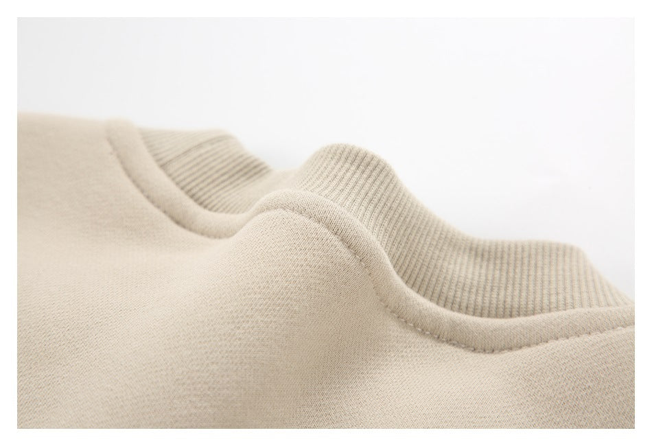 Angled close-up of the beige sweatshirt neckline and raised ribbed collar.
