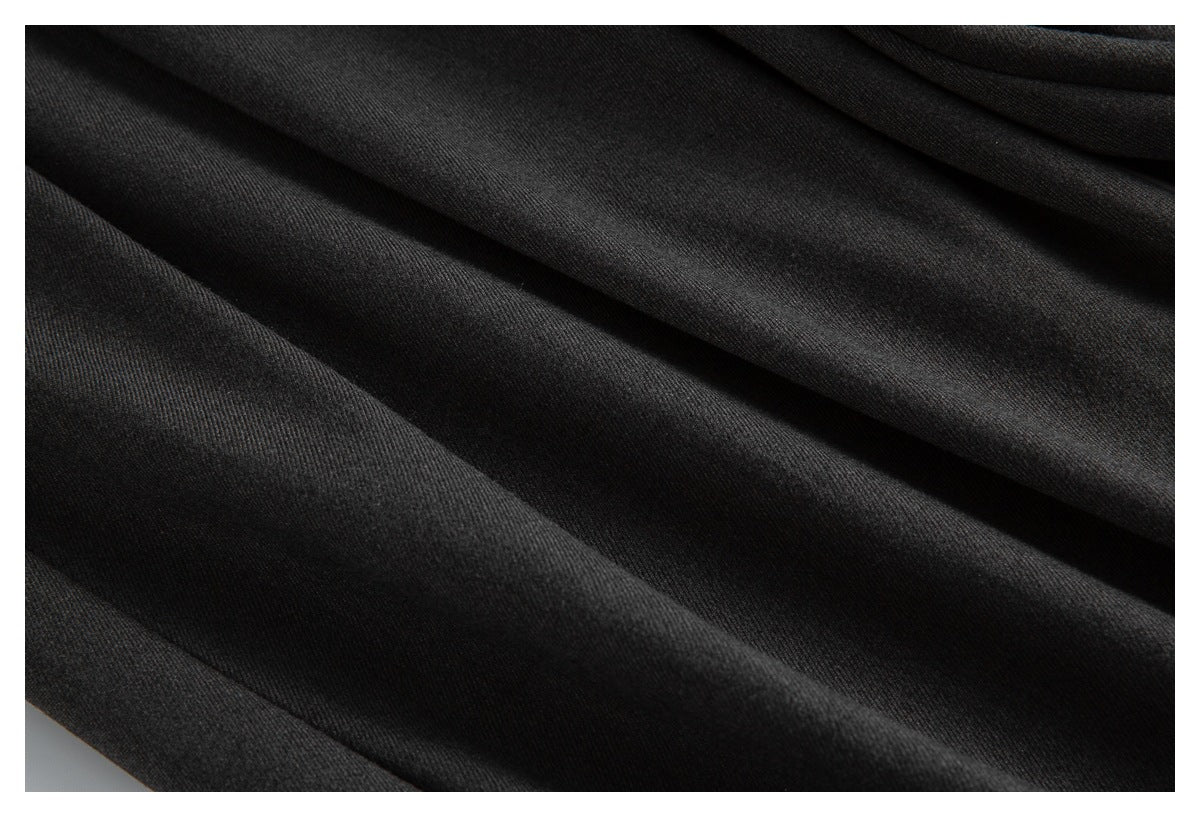 Close-up showing the dark charcoal fabric surface and folds of the trousers.