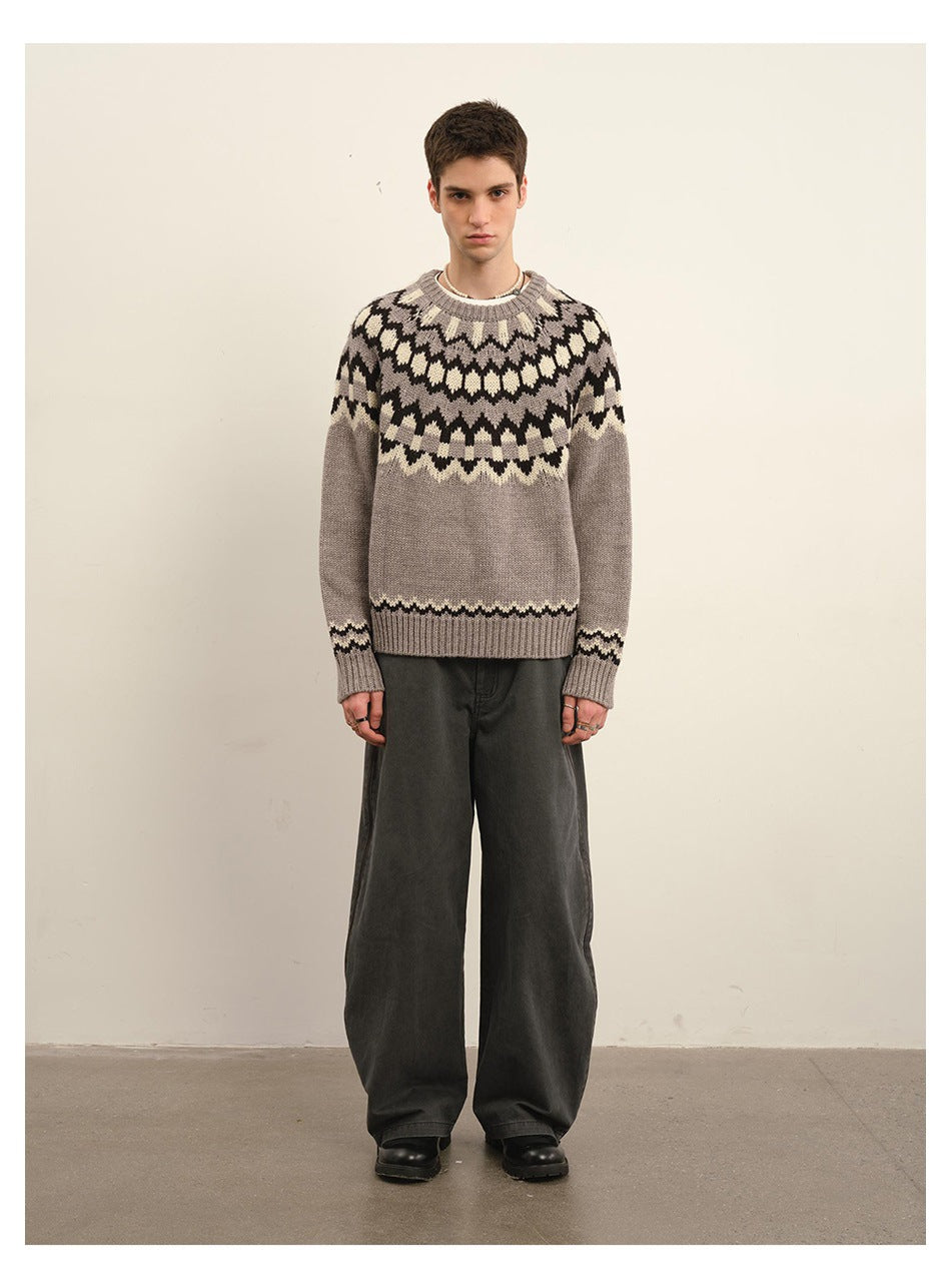 Front view of a model wearing a taupe Fair Isle crew-neck sweater with dark and cream patterns.