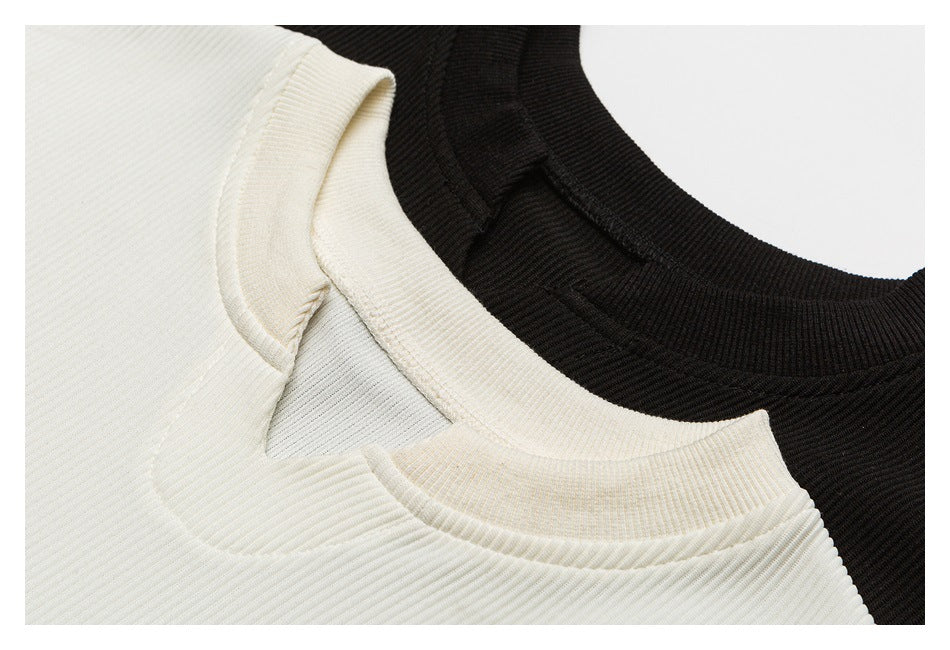 Close-up of the crew necklines and ribbed collars of ivory and black tops.