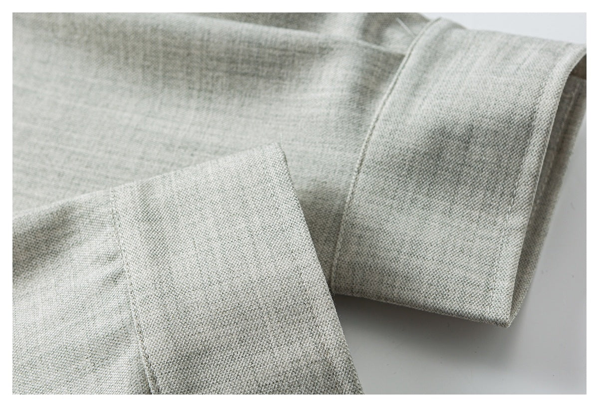 Close-up of a light gray shirt sleeve and folded cuff with visible stitching.