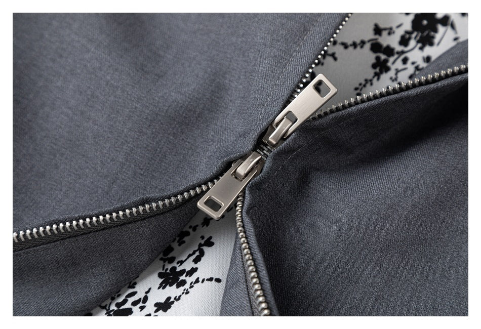 Close-up of a charcoal gray garment with a silver zipper and black floral-print lining.